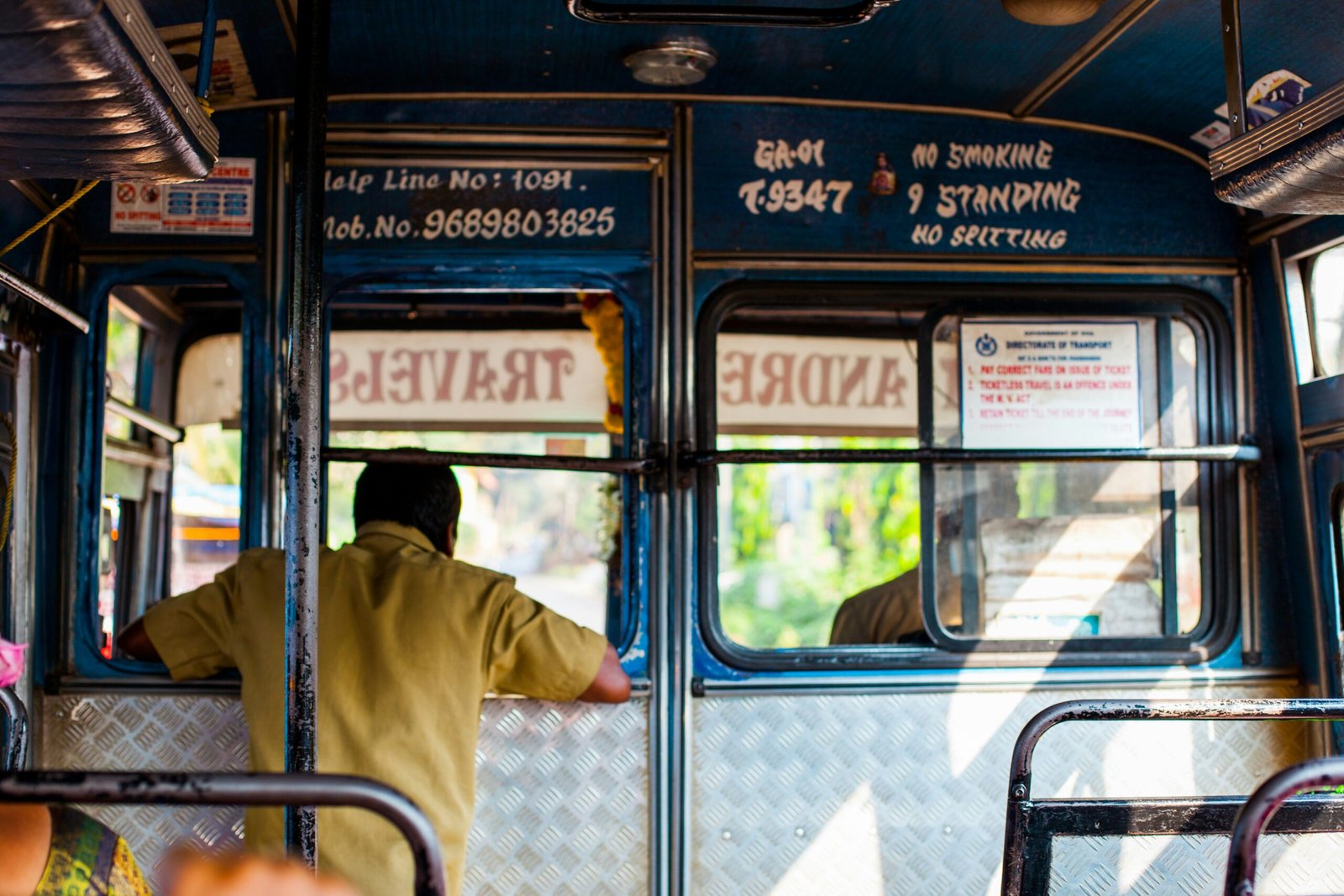 man in brown shirt leaning inside drivers side during daytime